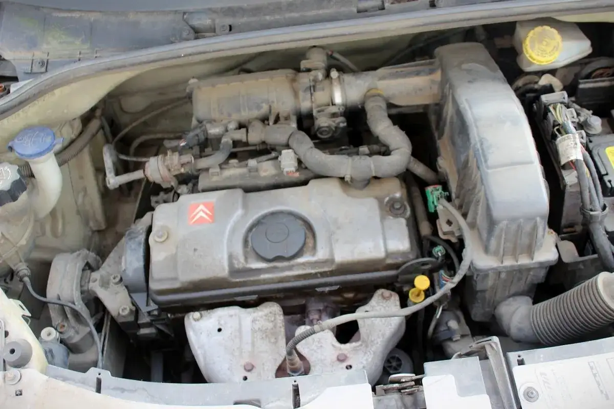 Silnik Citroen C3 2003, widok z góry, zakurzony, z widocznymi przewodami i elementami układu dolotowego.