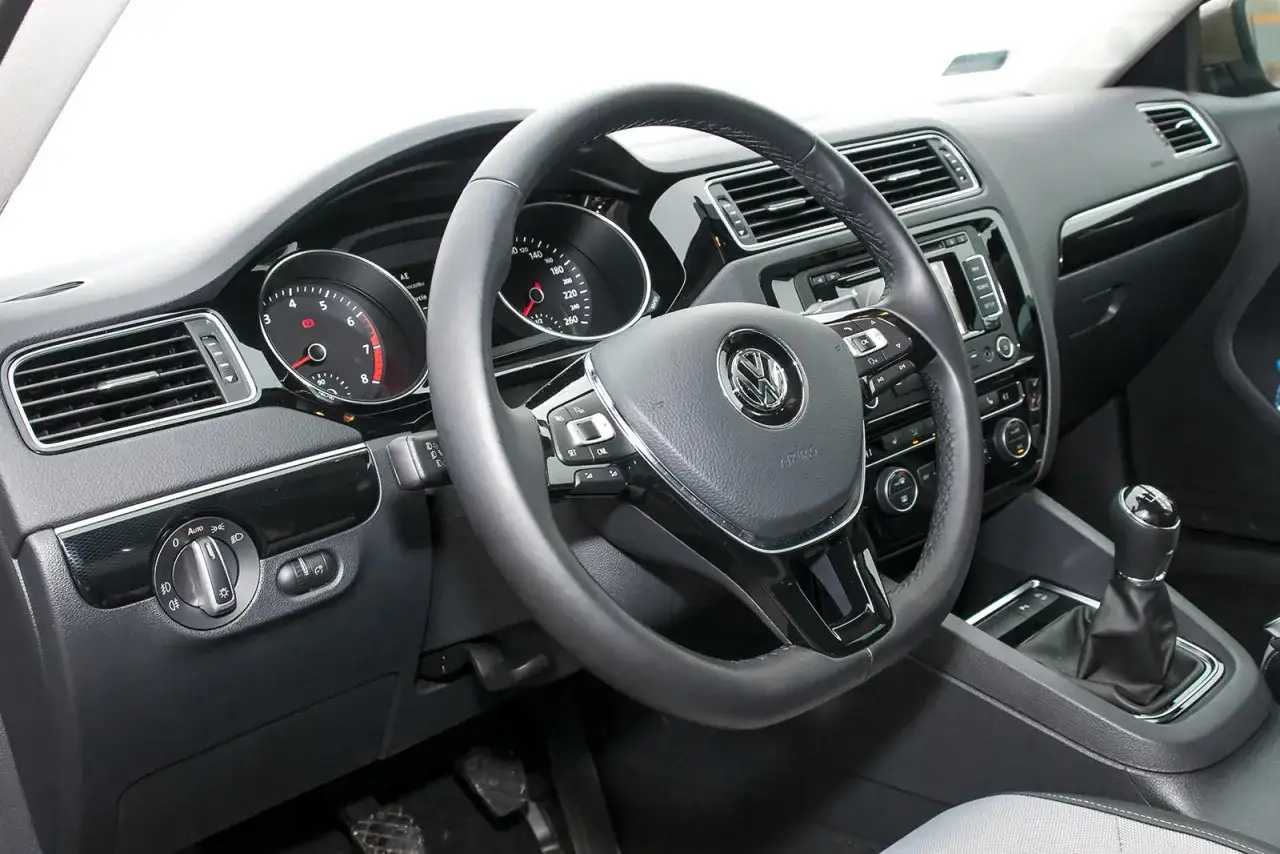 Wnętrze VW Jetta MK6: kierownica, deska rozdzielcza z zegarami i nawiewami, dźwignia zmiany biegów.