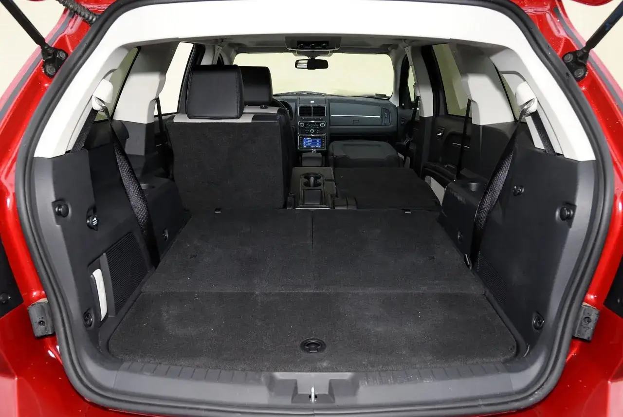 Wnętrze Dodge Journey z rozłożonymi siedzeniami, idealne na rodzinne wyjazdy. Sprawdź opinie o tym przestronnym aucie.