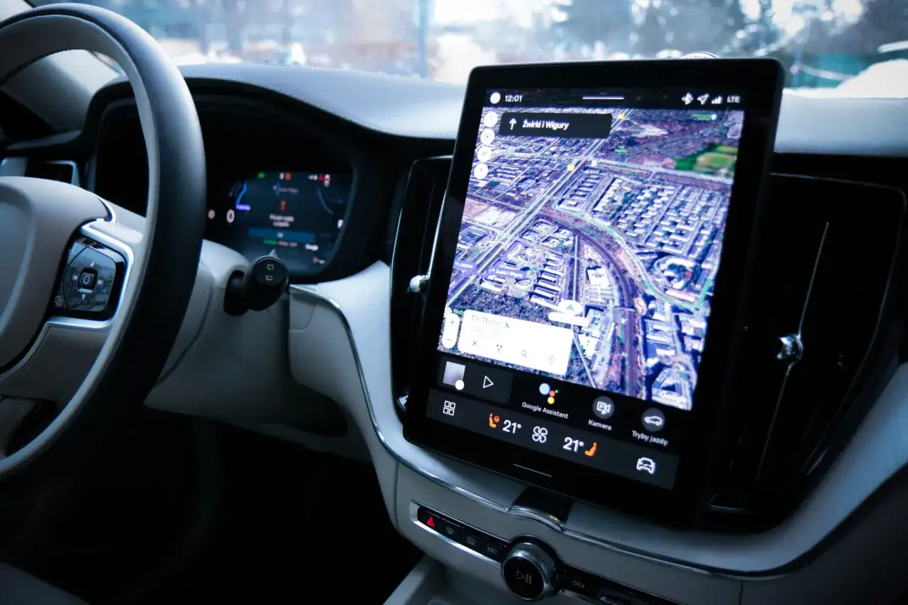 Wnętrze Volvo XC60 z nawigacją Google Maps. Kierownica i ekran multimedialny pokazują trasę. Wiele osób chwali volvo xc60 opinie o tym aucie są pozytywne.