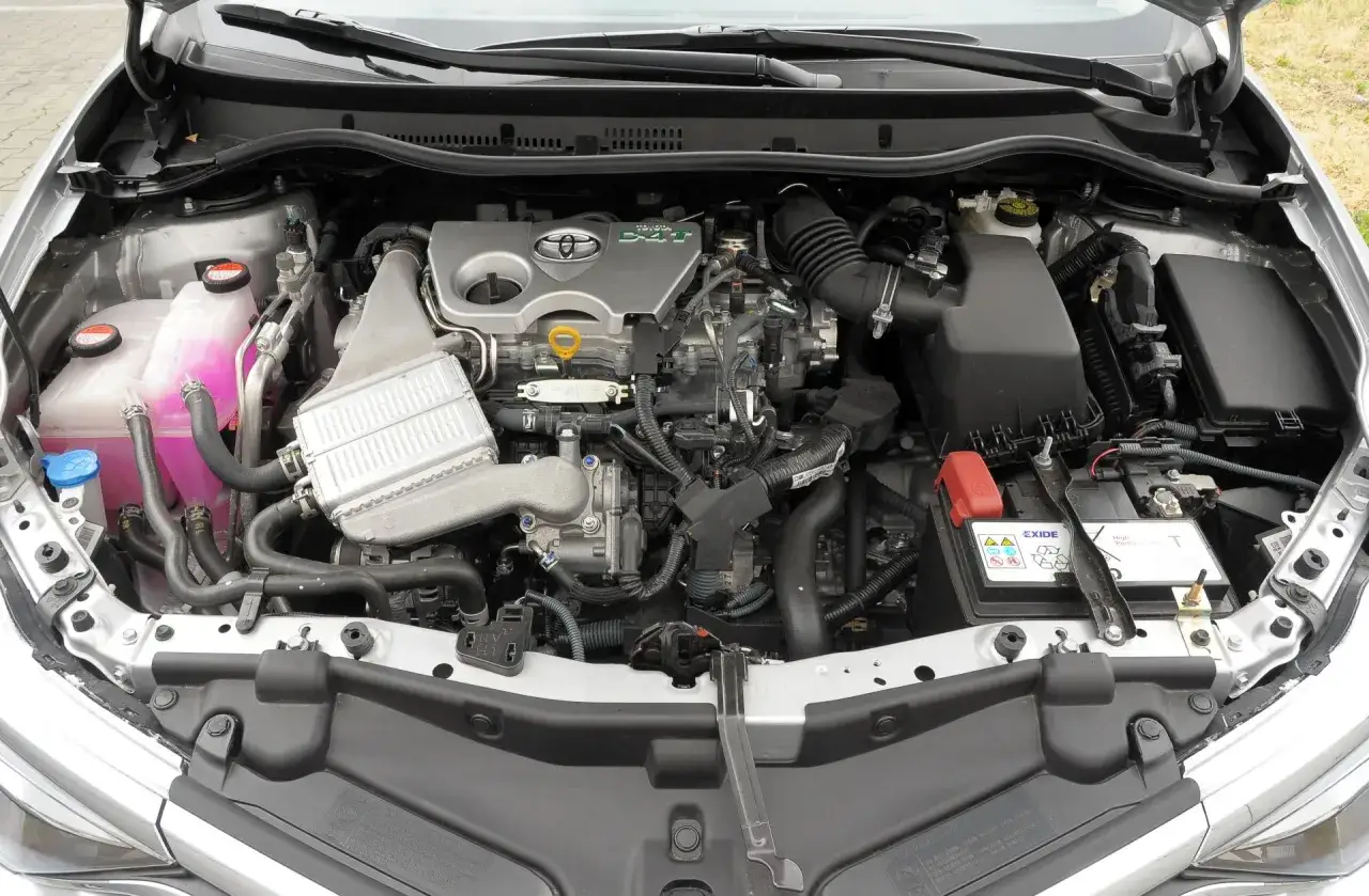 Silnik hybrydowy Toyoty Auris 2015 z widocznym zbiorniczkiem płynu chłodniczego i akumulatorem.