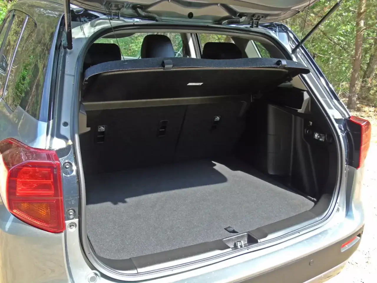Otwarty bagażnik Suzuki Vitara. Widoczne tylne siedzenia i przestrzeń bagażowa, która pozwala ocenić suzuki vitara wymiary.