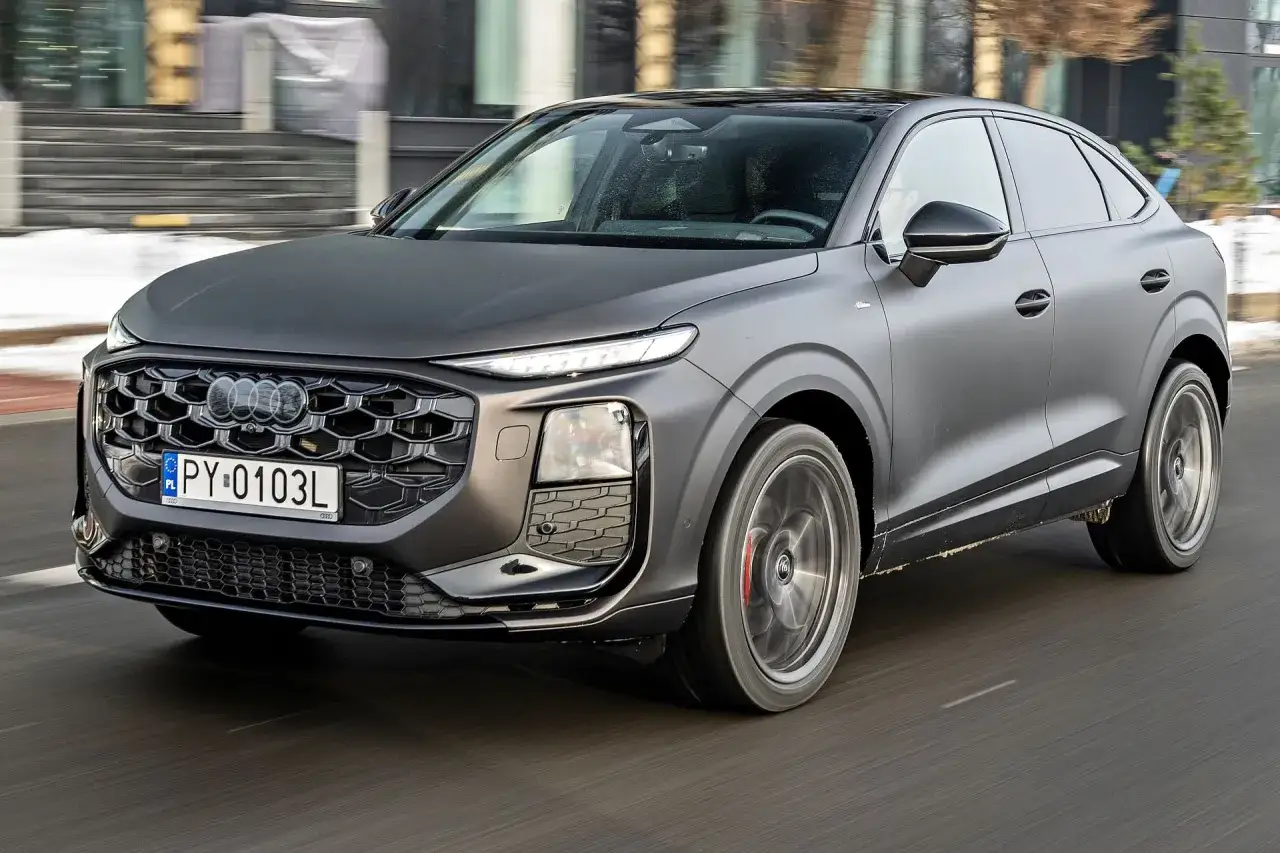 Matowy, ciemnoszary Audi Q3 Sportback w ruchu. Zwróć uwagę na jego sportowy wygląd i wymiary, idealne do miasta.