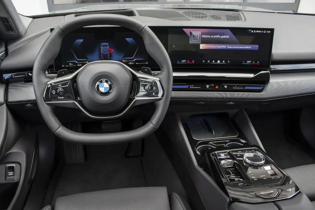 Wnętrze BMW 520d xDrive z nowoczesnym ekranem i kierownicą.