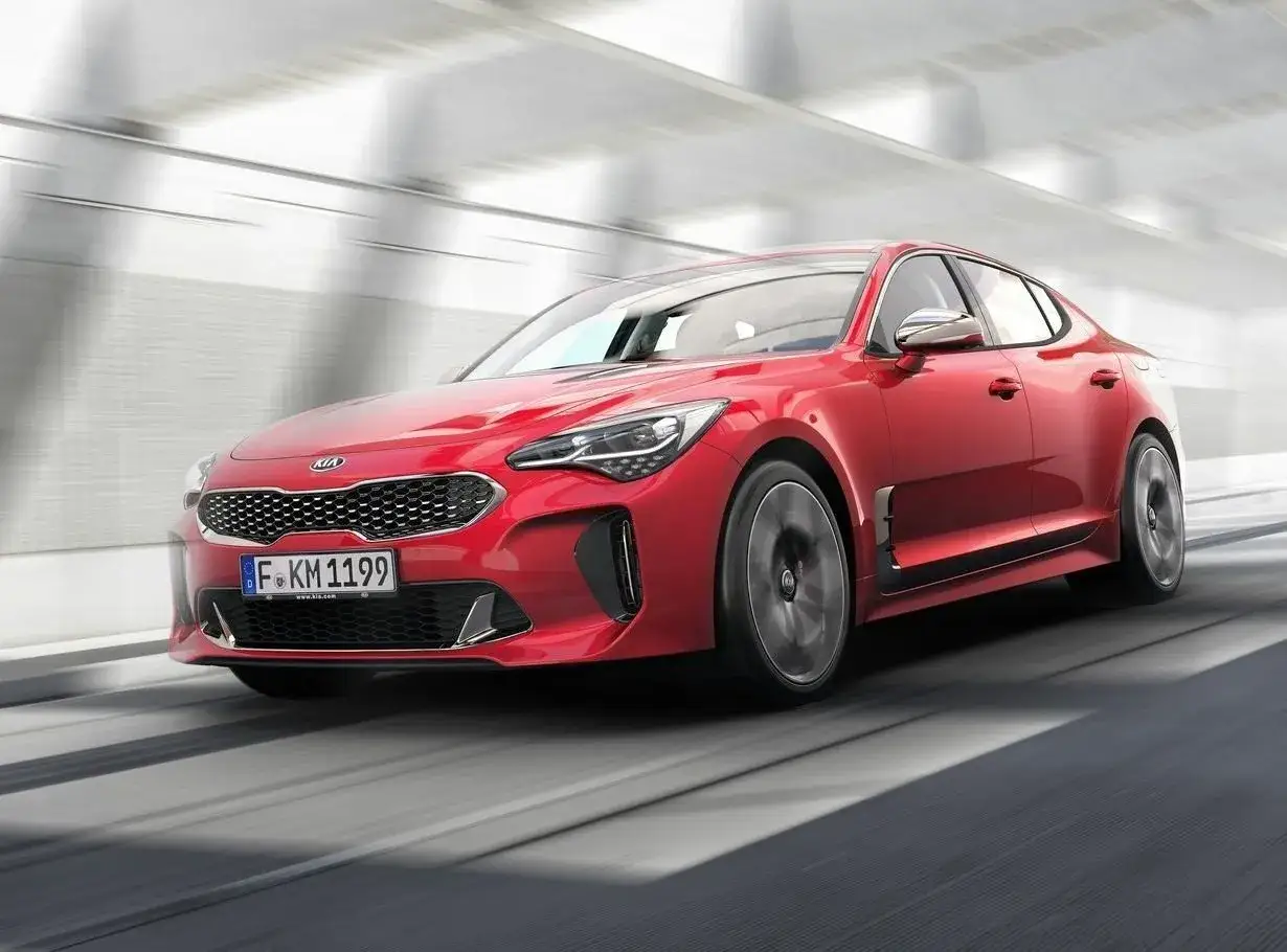 Czerwony Kia Stinger pędzi przez tunel. Wiele osób szuka kia stinger opinie, by poznać ten sportowy samochód.