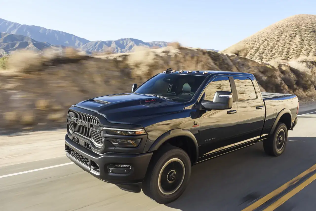 Czarny Dodge Ram 2500 z napędem 4x4 przemierza pustynną drogę wśród wzgórz.
