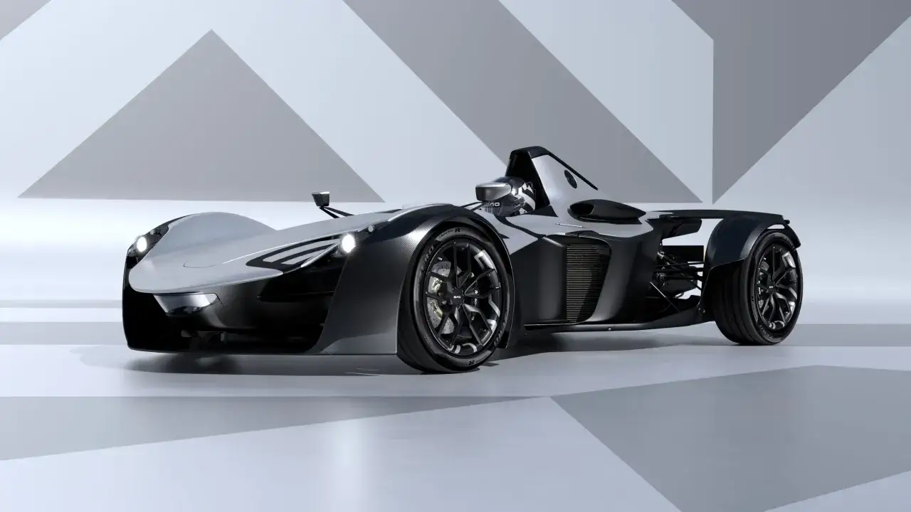 Srebrno-czarny BAC Mono, sportowy samochód jedoosobowy, prezentuje swoje aerodynamiczne kształty na tle geometrycznych wzorów.