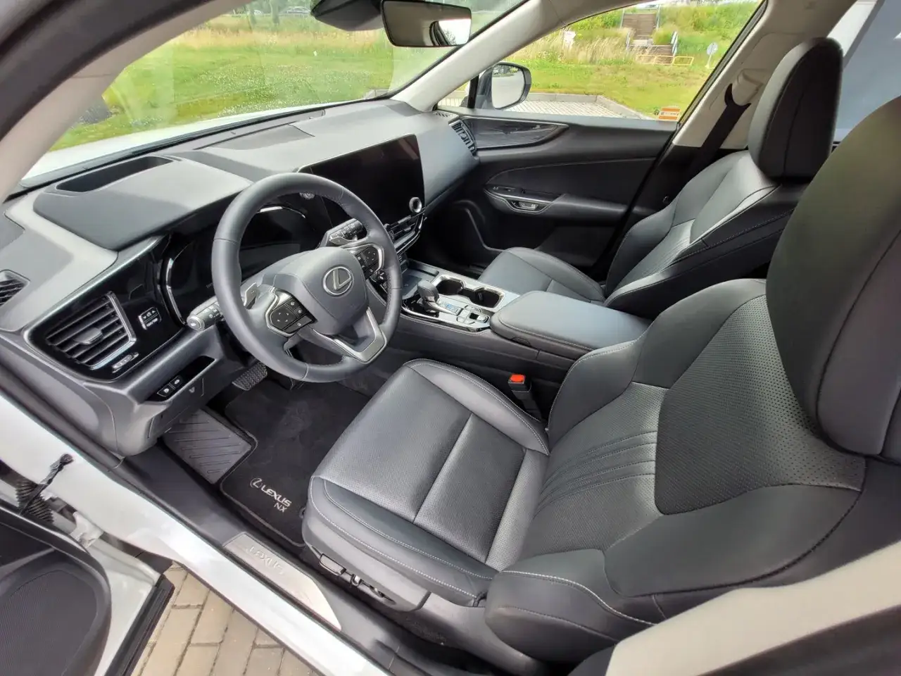 Wnętrze Lexus NX300h: skórzana tapicerka, nowoczesna deska rozdzielcza z dużym ekranem i kierownicą.