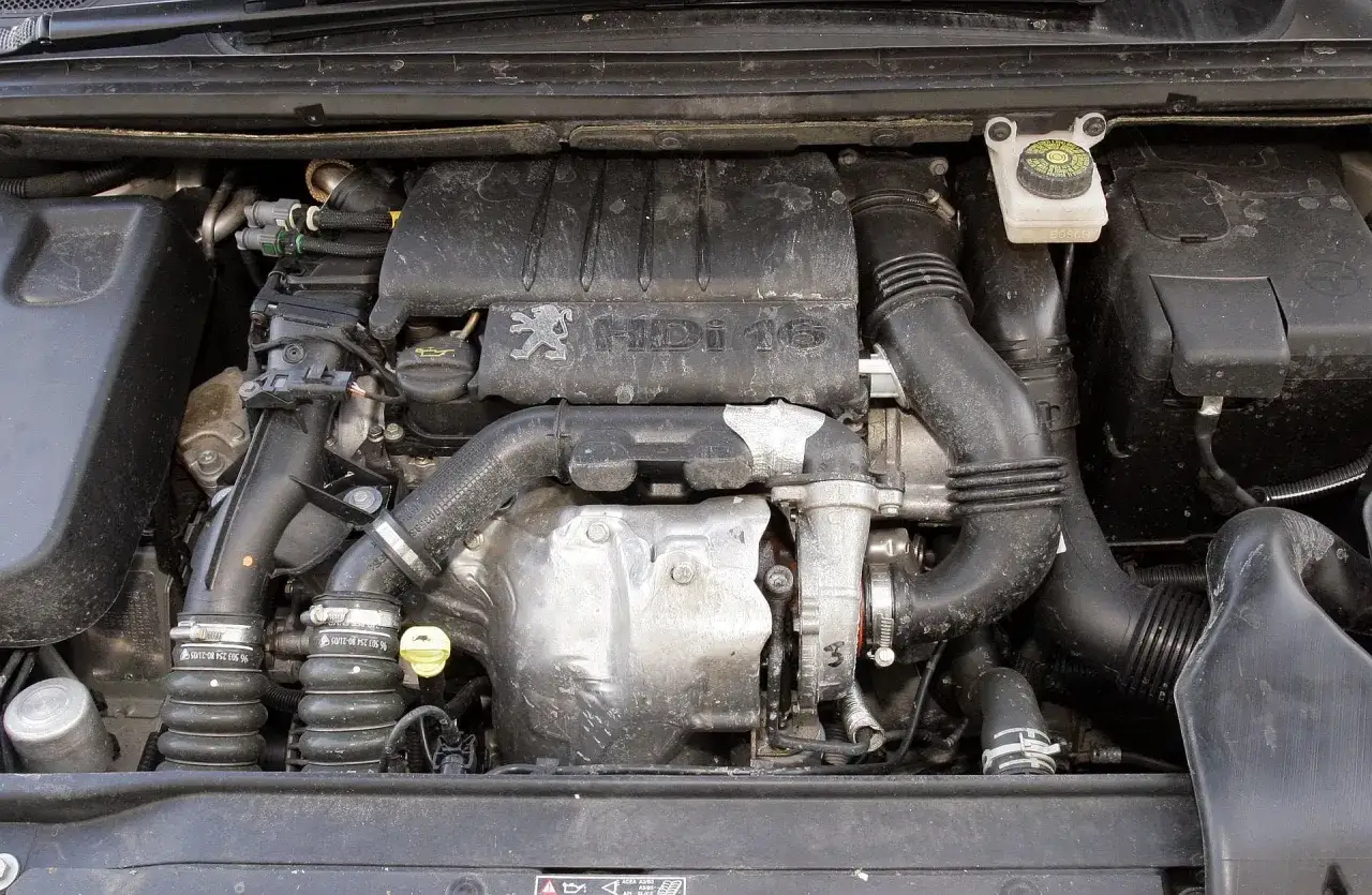 Silnik Peugeot 307 1.6 benzyna, widok z góry. Widać turbosprężarkę, przewody i osłony.