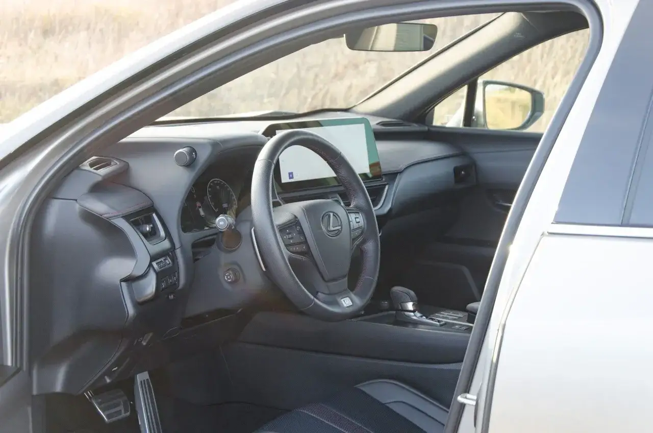 Wnętrze Lexusa UX, kierownica i ekran multimediów. Wiele osób szuka lexus ux opinie przed zakupem.