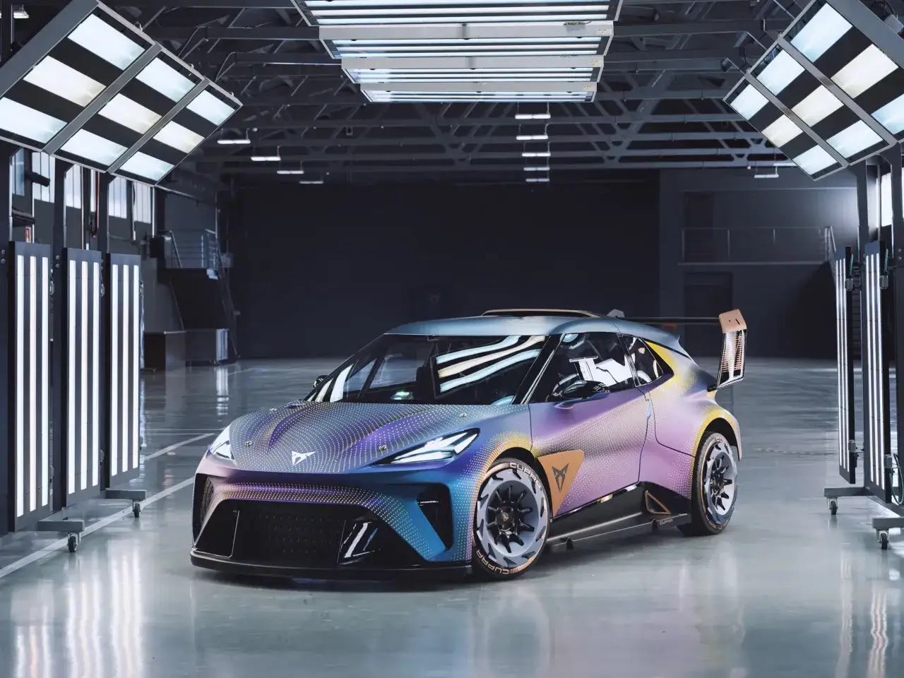 Futurystyczny Cupra sedan w unikalnym, opalizującym malowaniu, prezentowany w nowoczesnym studiu z oświetleniem.