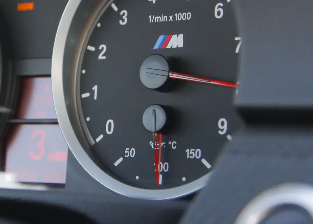 Wskaźnik pokazuje temperaturę oleju w silniku BMW M, wskazówka jest na 100°C.