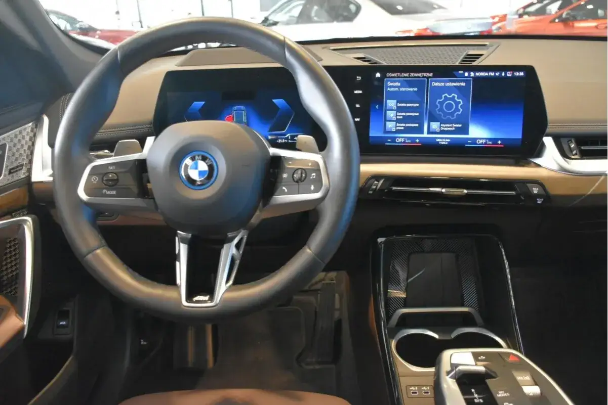 Wnętrze BMW X1 z nowoczesnym ekranem i kierownicą. Sprawdź aktualną bmw x1 cena i wyposażenie.