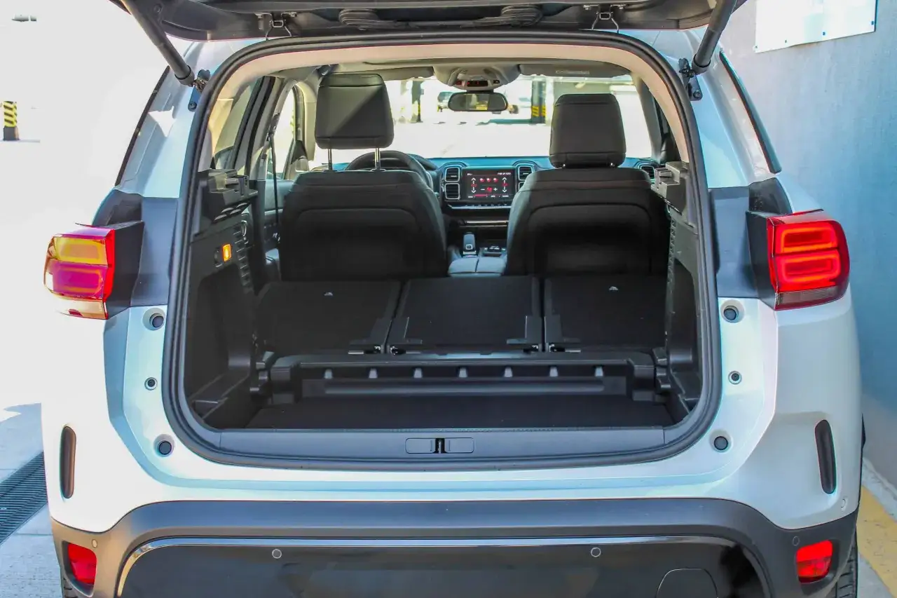 Wnętrze Citroen C5 Aircross z otwartym bagażnikiem i złożonymi tylnymi siedzeniami. Wiele miejsca na bagaż, co potwierdzają pozytywne citroen c5 aircross opinie.
