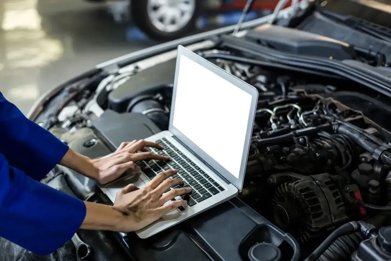 Mechanik diagnozuje silnik, sprawdzając dane na laptopie. Może to dotyczyć nawet starszych modeli z karburatorem.