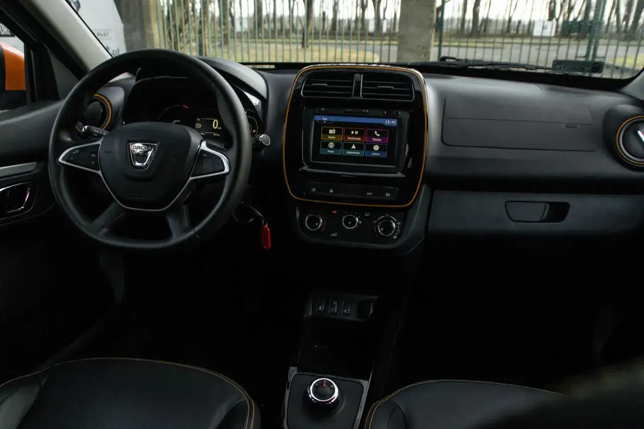 Wnętrze Dacii Spring, widok na kierownicę i ekran multimedialny. Dacia Spring opinie - prostota i funkcjonalność.
