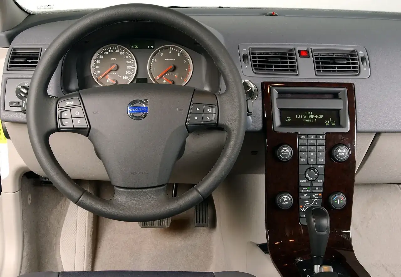 Wnętrze volvo hatchback: kierownica, deska rozdzielcza z radiem i nawiewami, dźwignia zmiany biegów.