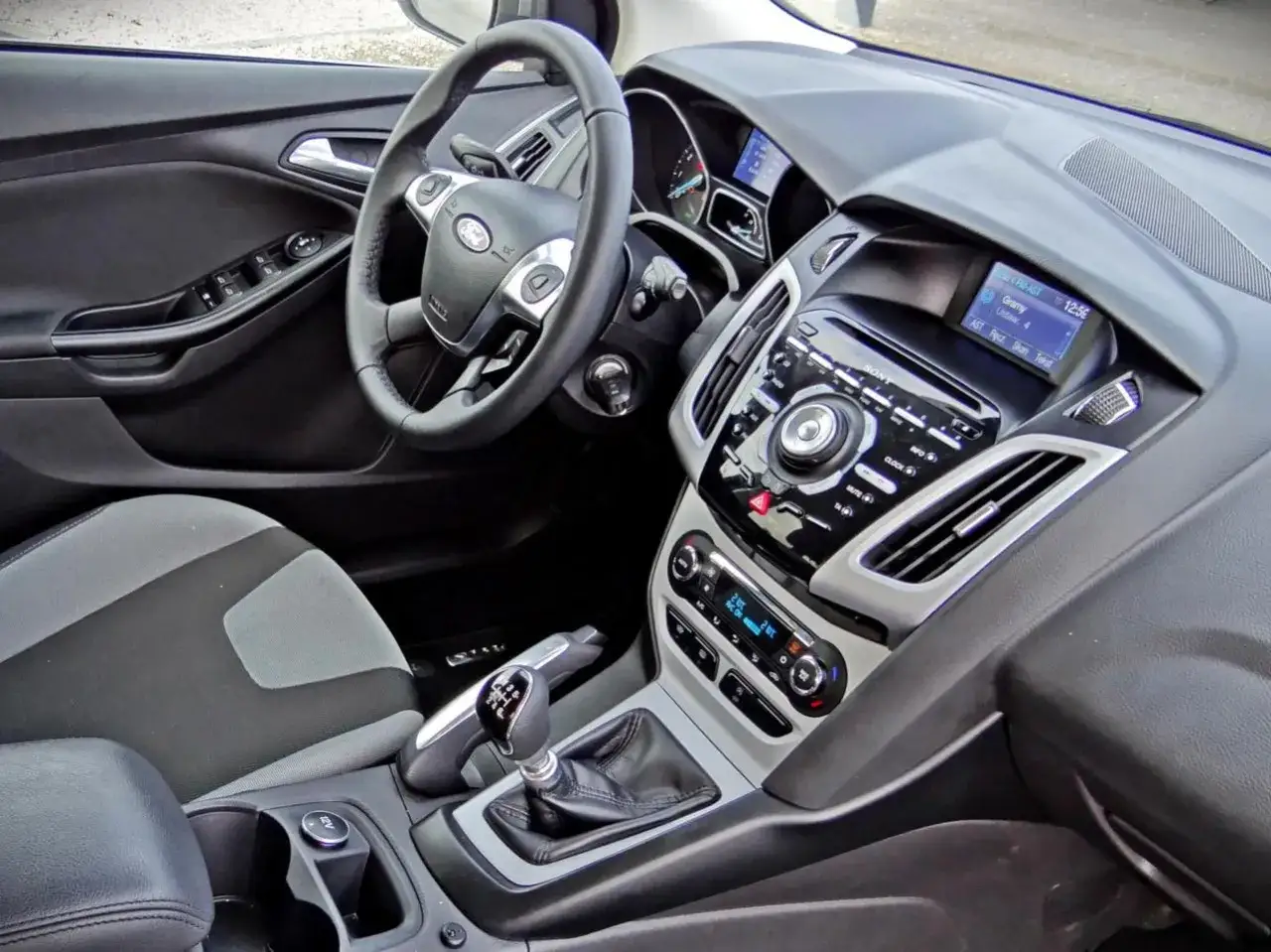 Wnętrze Forda Focusa MK3. Kierownica, deska rozdzielcza z radiem Sony i ekranem, dźwignia zmiany biegów. Wiele osób chwali to auto w swoich ford focus mk3 opinie.