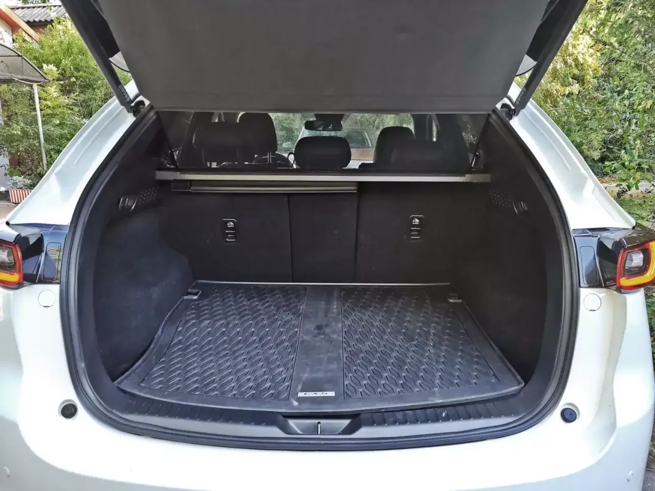 Bagażnik białej CX-5 Mazda z gumową matą i zasłonką. Gotowy na podróż!