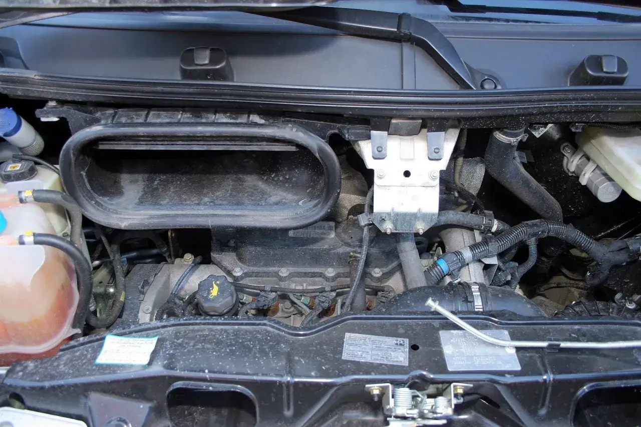 Silnik Fiat Ducato 2.3, widok komory silnika z przewodami i zbiorniczkami.