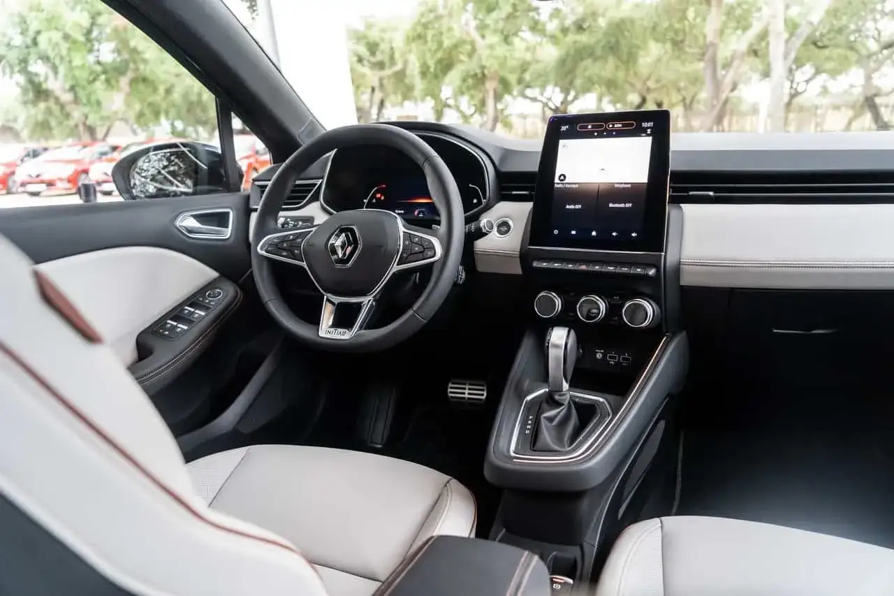 Wnętrze Renault Initiale: skórzana tapicerka, nowoczesny ekran multimedialny i kierownica z logo marki.