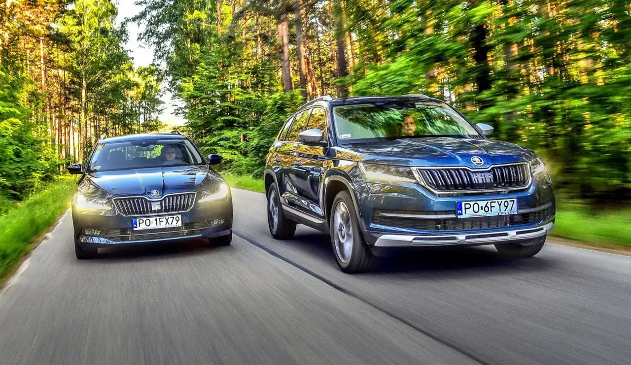 Dwie Skody jadące leśną drogą. Jedna to ciemny sedan, druga to niebieski SUV.