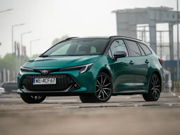 Zielona Toyota Corolla Touring Sports hybrid na mokrej nawierzchni.