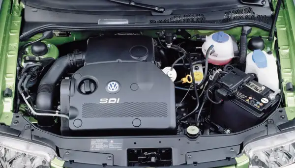 Silnik SDI Volkswagena, z widocznym logo i oznaczeniem, otoczony zielonymi elementami komory silnika.