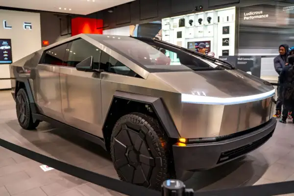 Futurystyczny Cybertruck Tesli błyszczy w salonie, gotowy na przygodę.