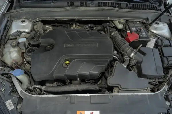Silnik Duratorq 2.0 TDCI w Fordzie Mondeo MK5. Widoczny akumulator, zbiornik płynu chłodniczego i elementy układu dolotowego.