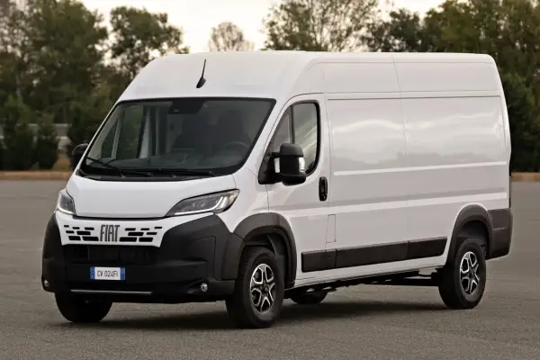 Biały Fiat Ducato Maxi, gotowy do transportu towarów, stoi na tle drzew.