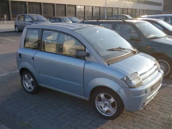Jasnoniebieski, miejski auto od 16 lat, zaparkowane na kostce brukowej.