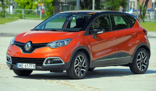 Pomarańczowy Renault Captur 2016 z czarnym dachem i pomarańczowymi akcentami, zaparkowany na placu.